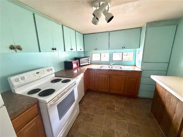 a kitchen with a stove a sink and a refrigerator