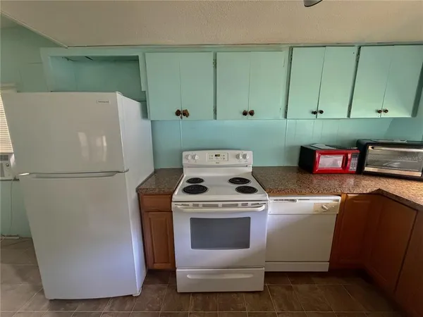 a kitchen with a stove top oven and cabinets