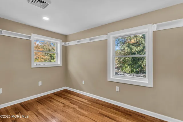 a view of room with window and wooden floor