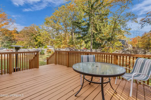 a view of a wooden chairs and table on the deck