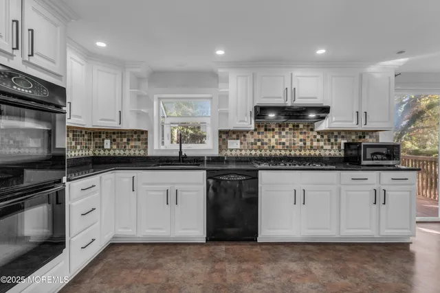 a kitchen with granite countertop white cabinets and stainless steel appliances