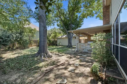 a view of a house with a tree in the yard