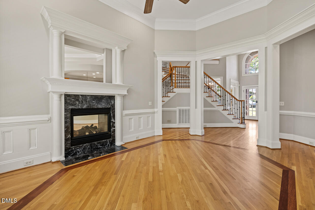 4004 Frontenac Court Apex, NC 27539 - Photo 12 of 61 an empty room with wooden floor fireplace and windows
