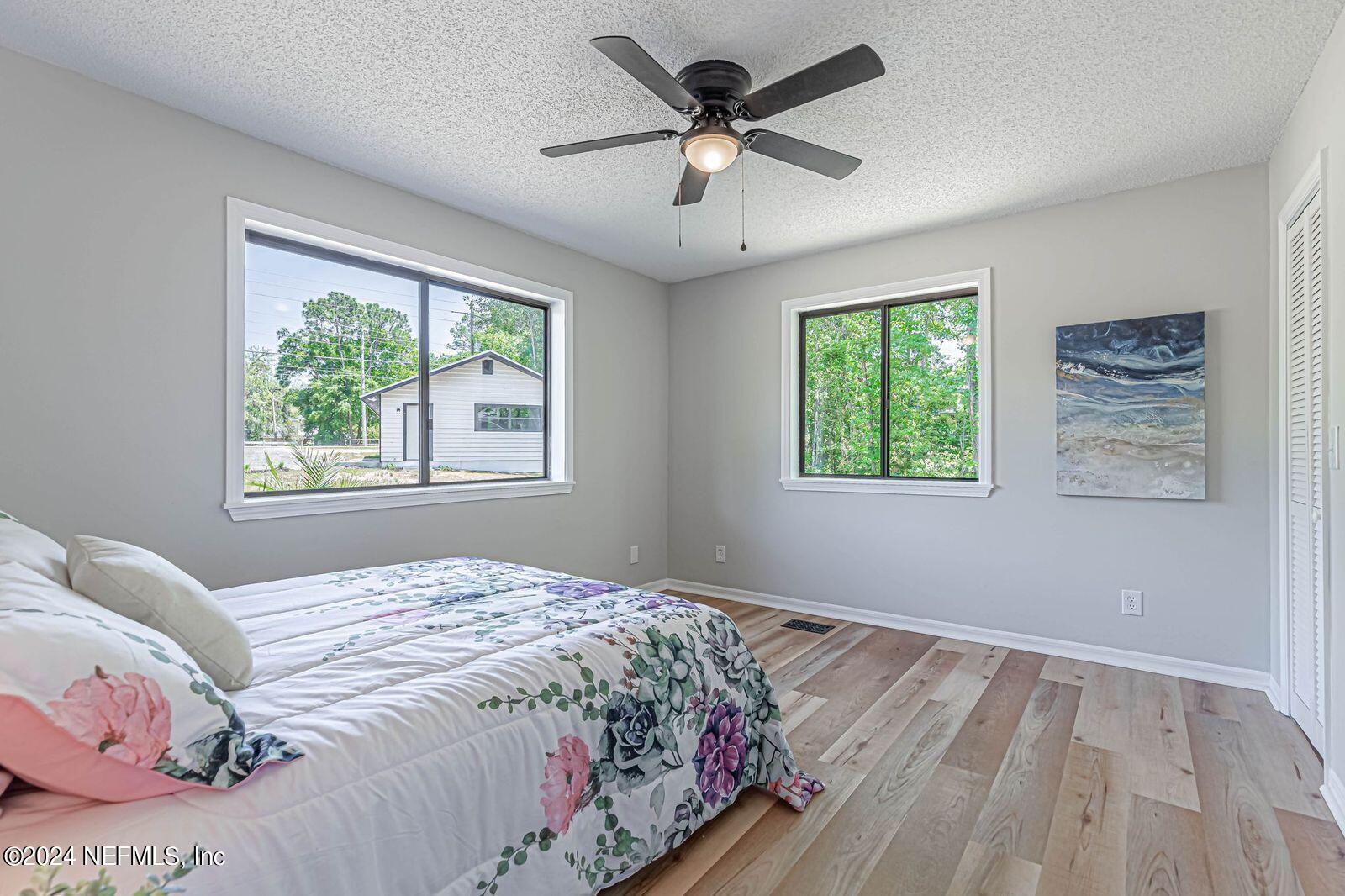 565 Roberts Road St. Johns, FL 32259 - Photo 40 of 79 a bedroom with a large bed window and a chandelier
