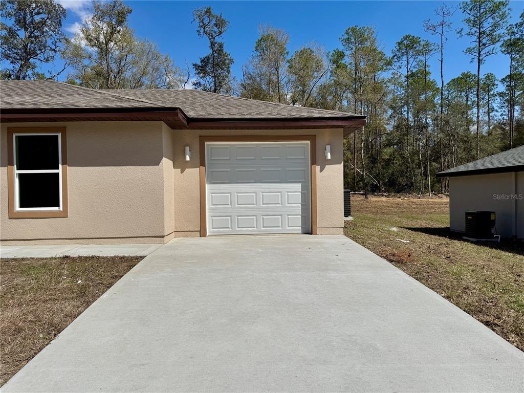 8601 North Stern Drive Citrus Springs, FL 34434 - Photo 17 of 18 a front view of a house with a yard and garage