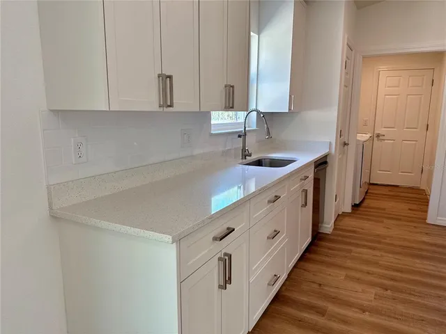 a kitchen with granite countertop white cabinets and sink