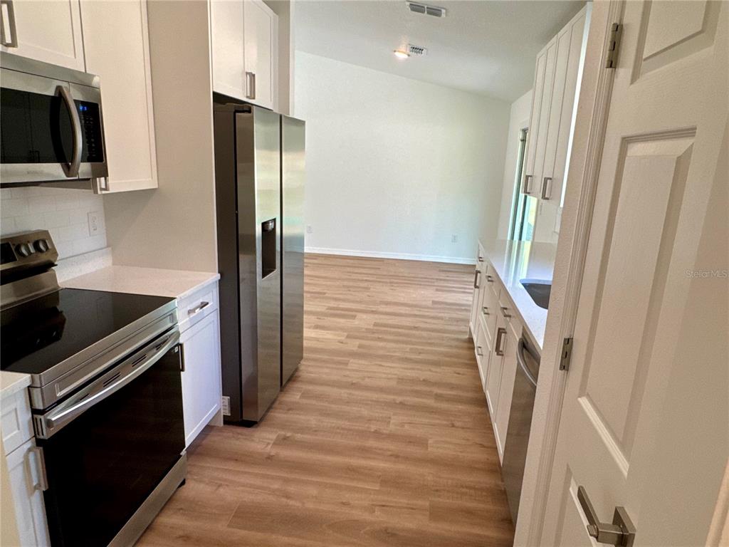 8601 North Stern Drive Citrus Springs, FL 34434 - Photo 6 of 18 a kitchen with a refrigerator stove and wooden floor