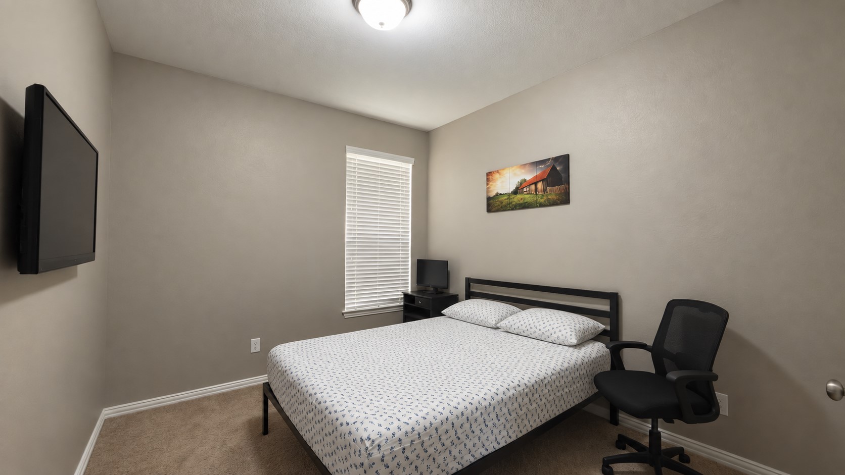Plush carpeting and a classic sash window define this versatile secondary bedroom space.