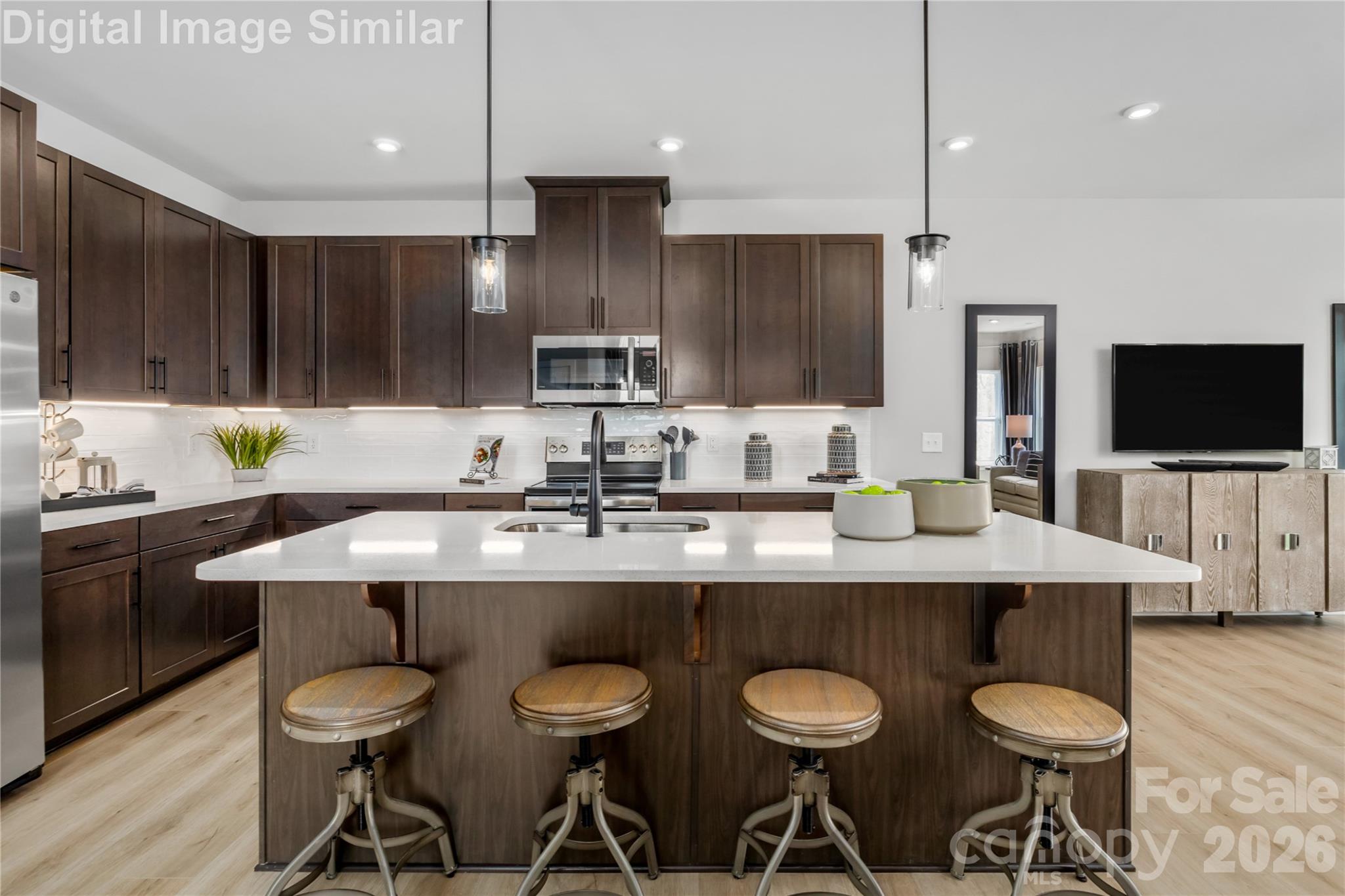 9569 Teamwork Street Northwest Concord, NC 28027 - Photo 2 of 23 a kitchen with stainless steel appliances granite countertop a sink a stove a kitchen island and chairs with wooden floor