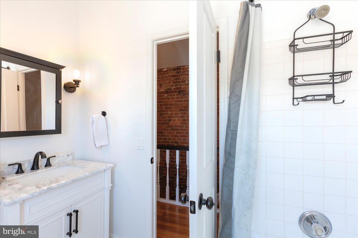 1118 F Street Northeast Washington, DC 20002 - Photo 26 of 62 a bathroom with a granite countertop sink and a mirror