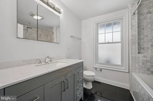a bathroom with a sink toilet vanity and tub