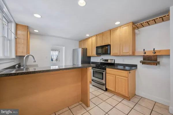 a kitchen with granite countertop a sink and white cabinets