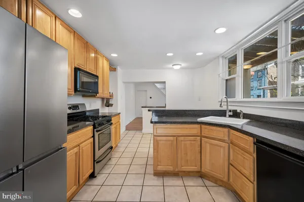 a open kitchen with stainless steel appliances granite countertop a sink and a stove