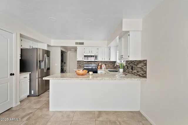 a kitchen with stainless steel appliances a refrigerator sink and stove