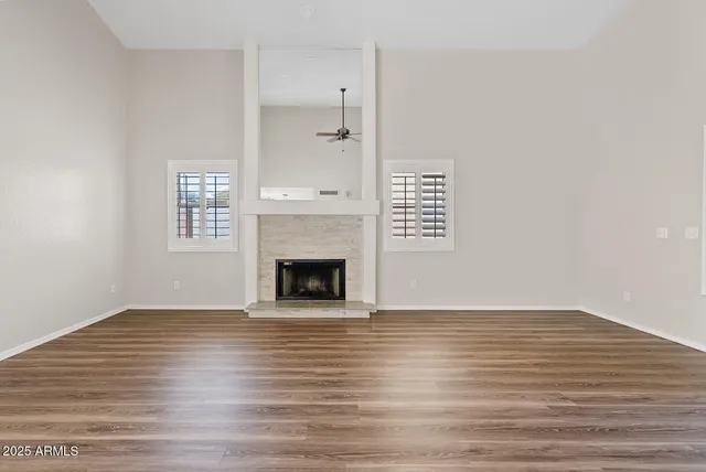 a view of empty room with wooden floor and fireplace