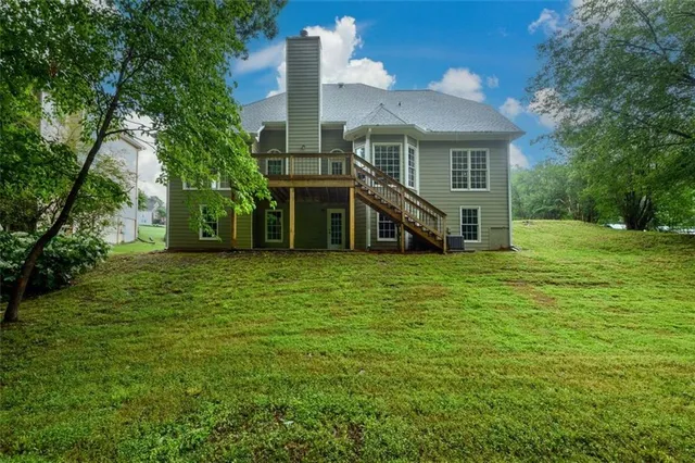 a view of a big house with a big yard and large trees