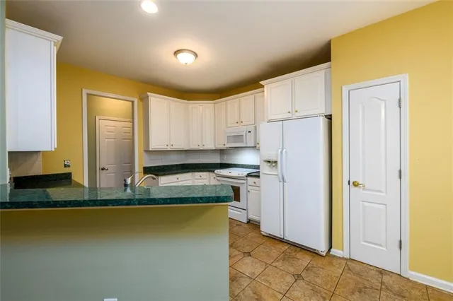 a kitchen with stainless steel appliances granite countertop a refrigerator a stove and a sink