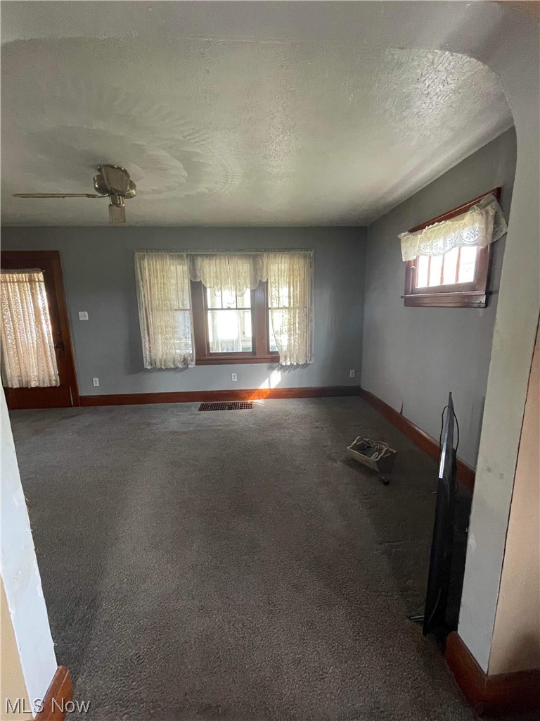 2578 Alexander Road Atwater, OH 44201 - Photo 5 of 19 Unfurnished room with dark colored carpet, a textured ceiling, plenty of natural light, and ceiling fan