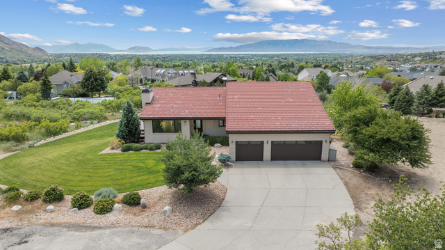 4221 Juniper Circle Alpine, UT 84004 - Photo 55 of 66 Two-car garage with a concrete driveway, featuring a terracotta tile roof and light-colored siding
