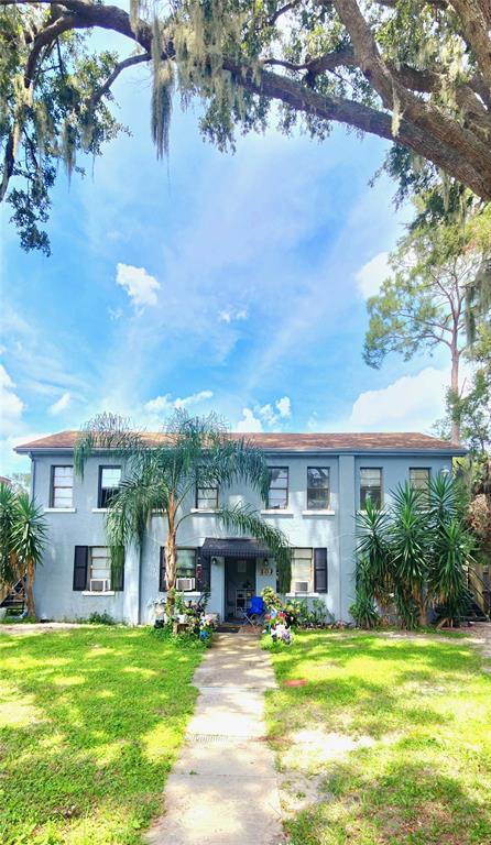 301 Ave B Southeast, Unit 4 Winter Haven, FL 33880 - Photo 2 of 16 a front view of a house with a garden and trees