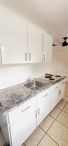 a kitchen with granite countertop white cabinets and white appliances