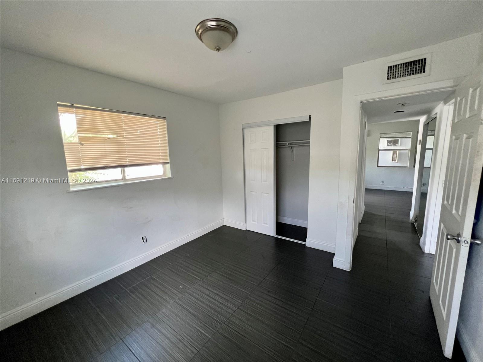 37 Southwest 14th Street, Unit 16 Dania Beach, FL 33004 - Photo 11 of 11 an empty room with wooden floor and windows