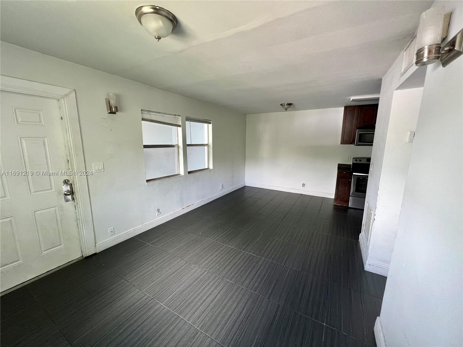 37 Southwest 14th Street, Unit 16 Dania Beach, FL 33004 - Photo 5 of 11 wooden floor in an empty room with a window