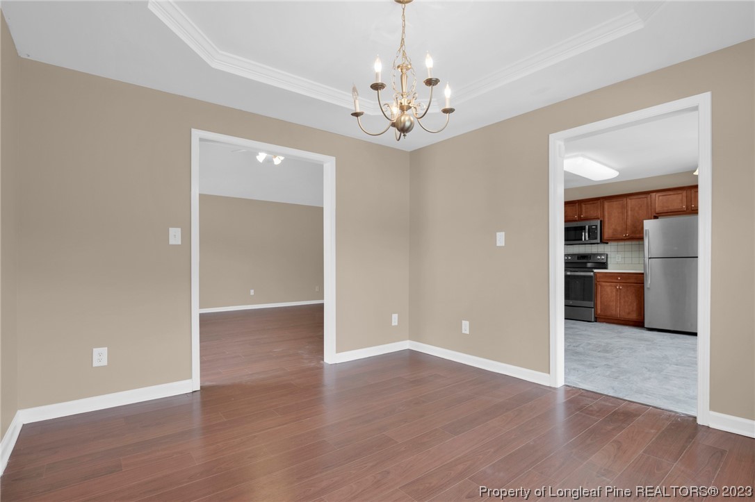 66 Pender Road Spring Lake, NC 28390 - Photo 11 of 35 a view of a room with wooden floor kitchen view and a chandelier