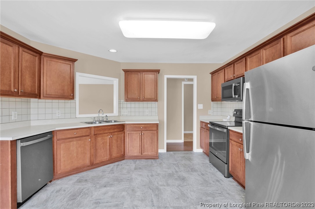 66 Pender Road Spring Lake, NC 28390 - Photo 12 of 35 a large kitchen with stainless steel appliances granite countertop a refrigerator a stove a sink and a microwave