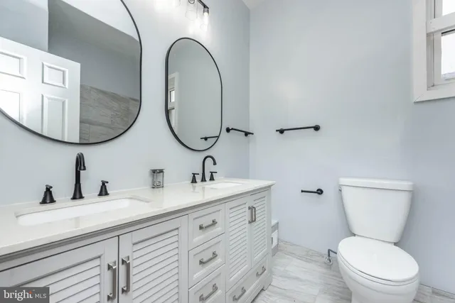 a bathroom with a toilet a sink and mirror