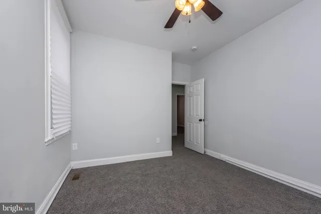 an empty room with a empty space and a ceiling fan