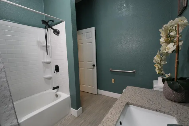 a bathroom with a granite countertop sink a toilet and shower