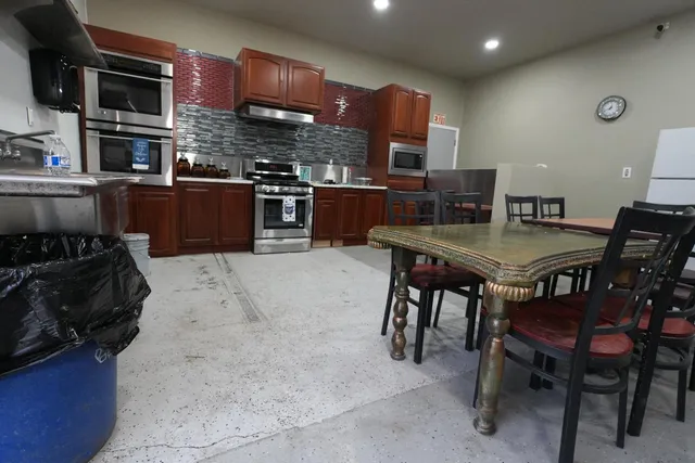 a view of kitchen with stainless steel appliances kitchen island granite countertop a table and chairs in it