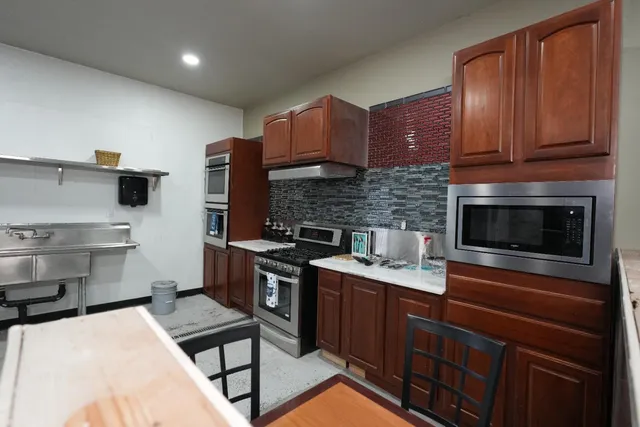 a kitchen with stainless steel appliances a stove sink microwave and cabinets