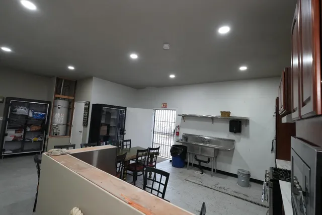 a living room with stainless steel appliances furniture and a flat screen tv