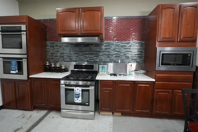 a kitchen with granite countertop a stove and a microwave