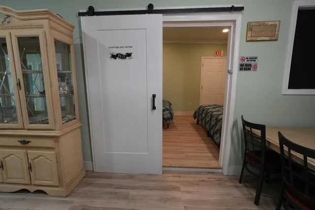 a view of a hallway with wooden floor and a living room