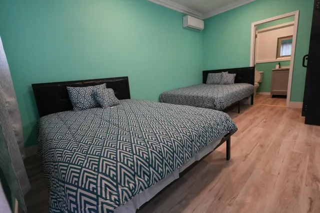 a bedroom with bed and wooden floor