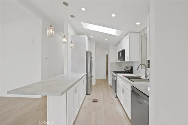 a kitchen with stainless steel appliances a sink stove and refrigerator