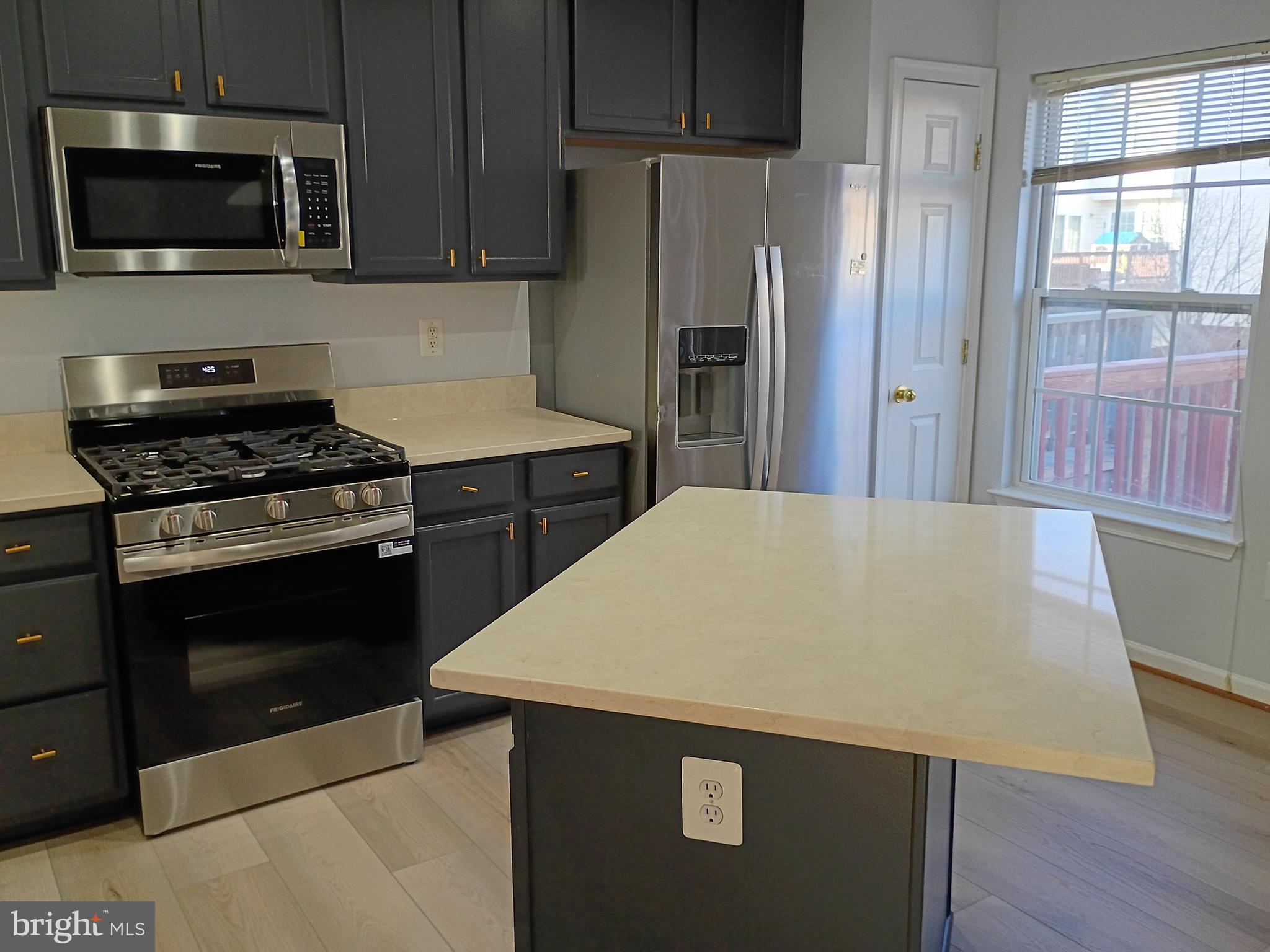 9707 Selfridge Road Baltimore, MD 21220 - Photo 12 of 22 a kitchen with stainless steel appliances a stove a microwave and a refrigerator