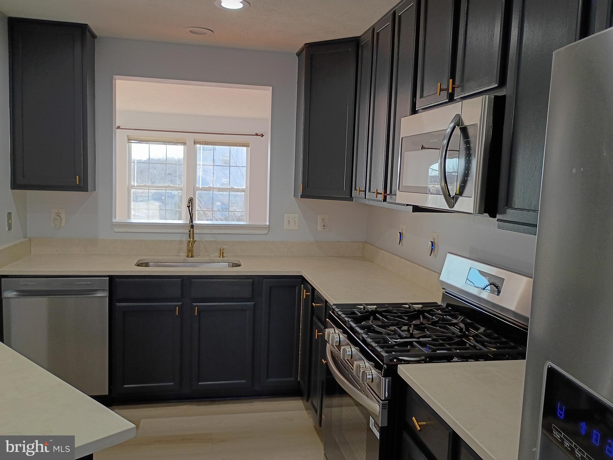 9707 Selfridge Road Baltimore, MD 21220 - Photo 13 of 22 a kitchen with granite countertop a sink stove and cabinets