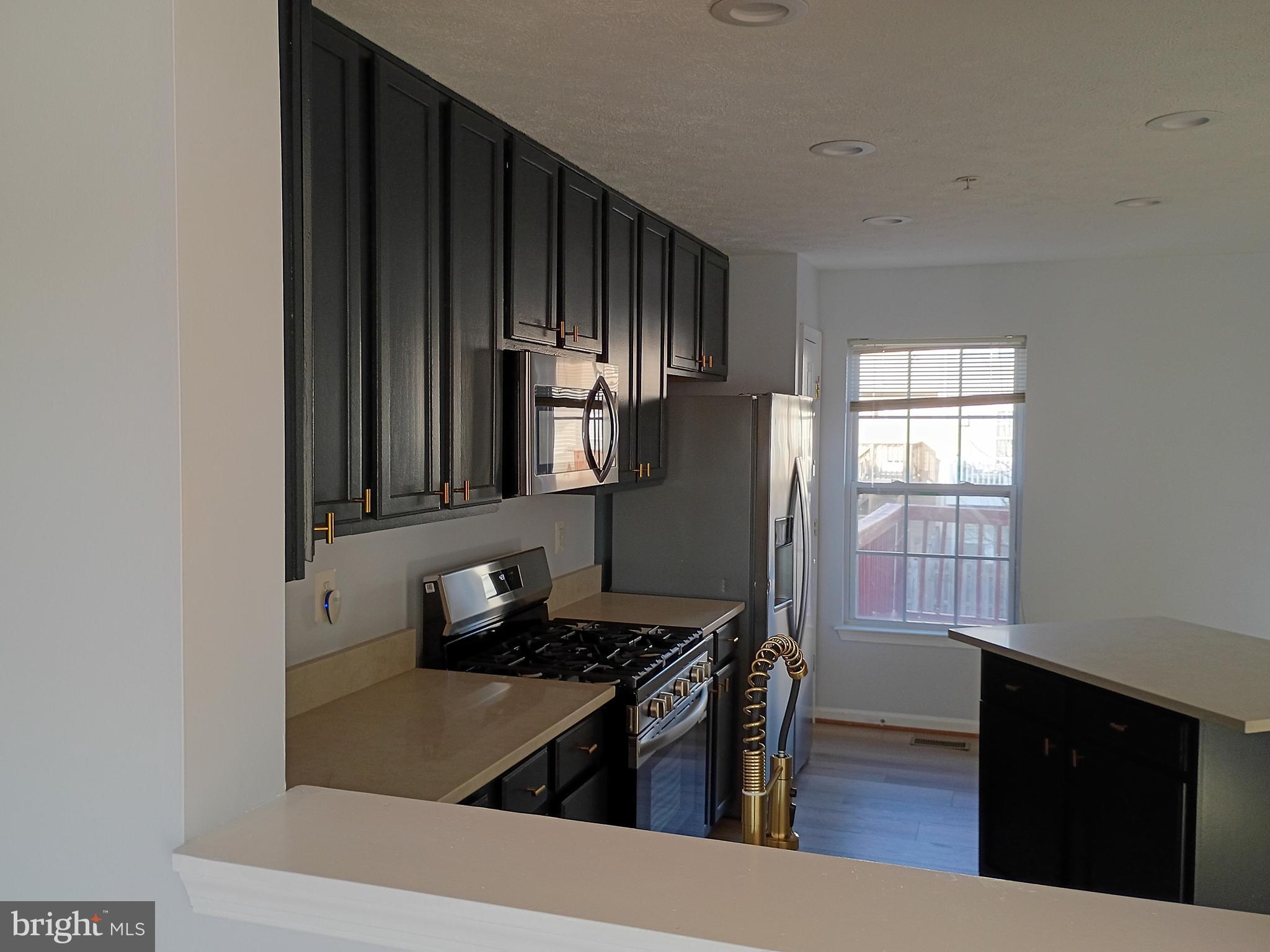 9707 Selfridge Road Baltimore, MD 21220 - Photo 10 of 22 a kitchen with wooden cabinets and a stove top oven