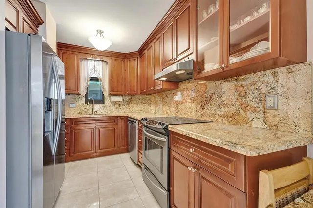 a kitchen with stainless steel appliances granite countertop a stove and a refrigerator