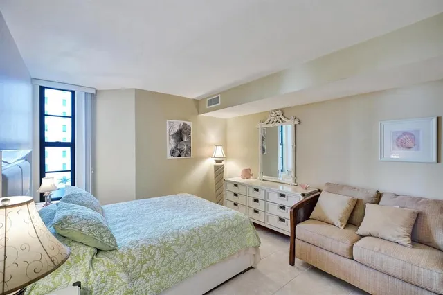 a bedroom with a bed couch and window