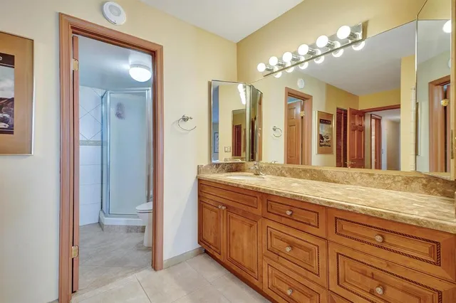 a spacious bathroom with a granite countertop sink a mirror and a shower