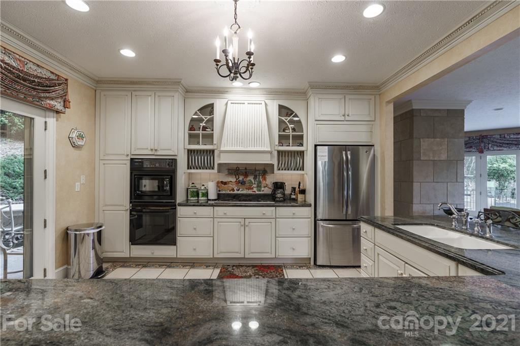 454 Cut Away Road Lake Lure, NC 28746 - Photo 19 of 48 a kitchen with stainless steel appliances granite countertop a refrigerator a stove a sink and a refrigerator