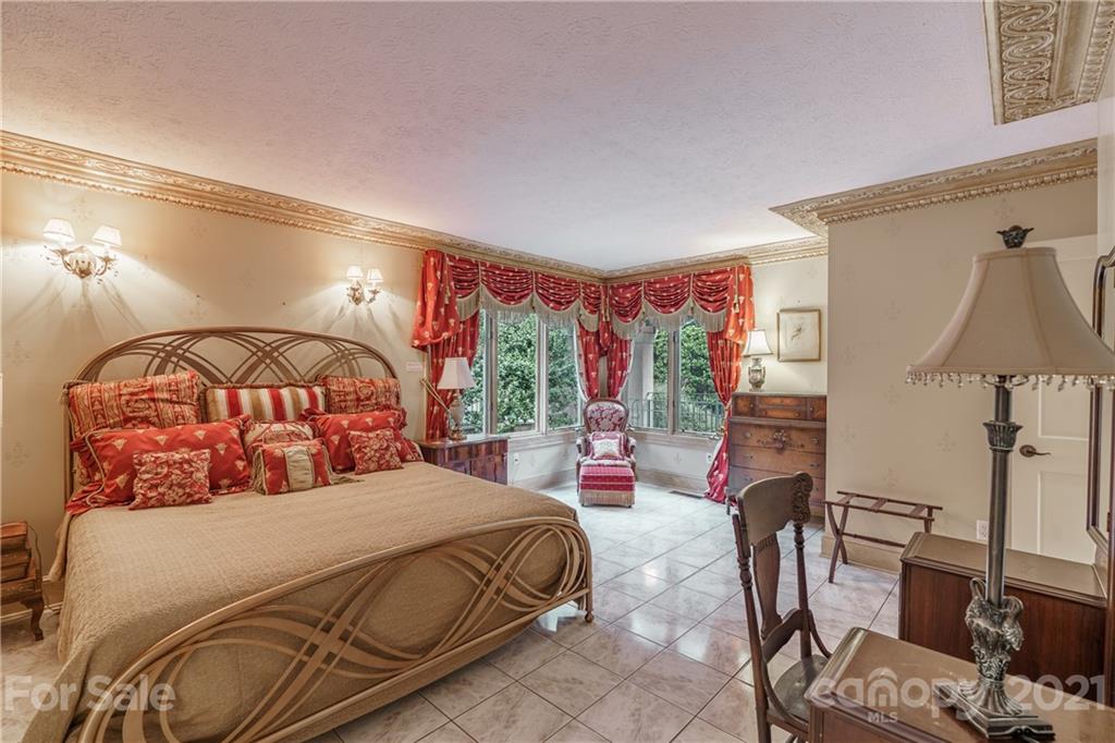 454 Cut Away Road Lake Lure, NC 28746 - Photo 28 of 48 a bedroom with a bed a lamp and a large window