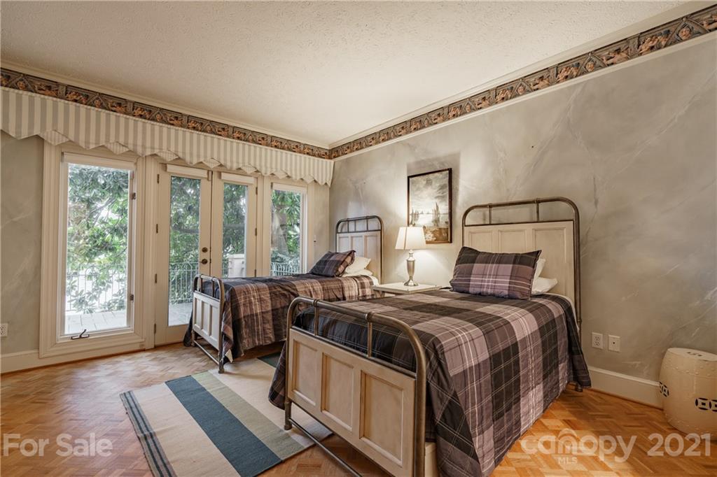 454 Cut Away Road Lake Lure, NC 28746 - Photo 37 of 48 a bedroom with a bed a chandelier and a window