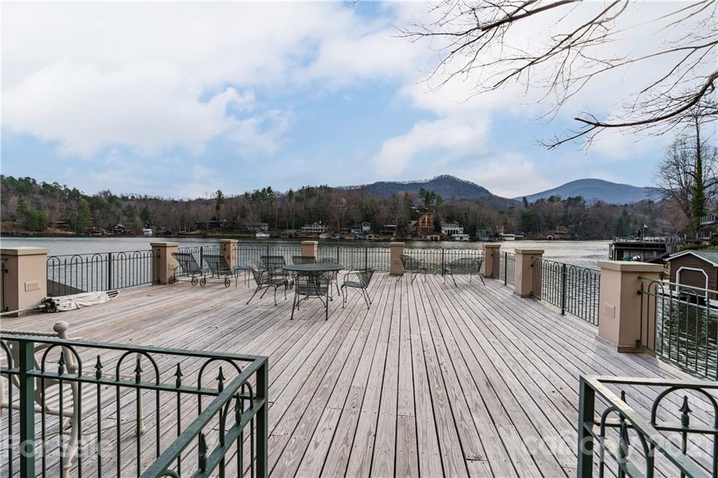 454 Cut Away Road Lake Lure, NC 28746 - Photo 5 of 48 a view of a roof deck with table and chairs a barbeque with wooden floor and fence