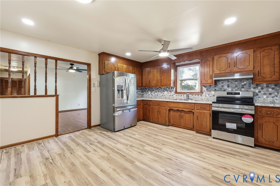 2521 Fort Lee Road Petersburg, VA 23805 - Photo 7 of 27 a kitchen with stainless steel appliances kitchen island granite countertop a refrigerator a sink and a stove